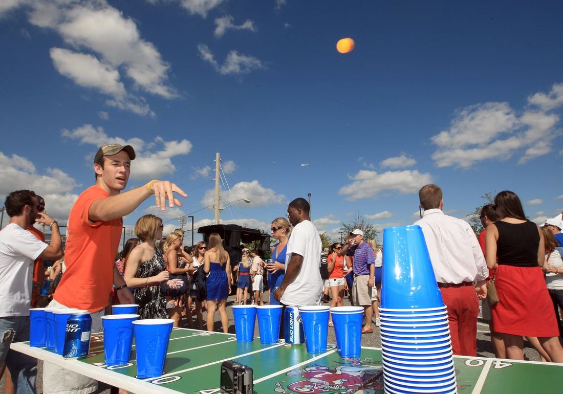 Fans playing a tailgate game in the parking lot before kickoff