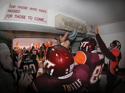 Players touching the stone in the tunnel before running out